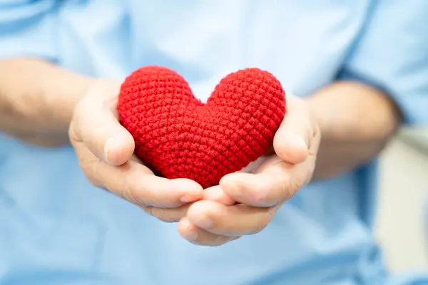 Hastanede kalbi kırmızı olan Asyalı yaşlı bir kadın..