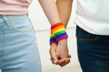 Gökkuşağı bilekliği takan Asyalı LGBT çifti..