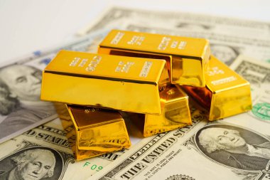 Gold bars on US dollar banknote money, finance trading investment business currency concept.