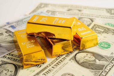 Gold bars on US dollar banknote money, finance trading investment business currency concept.