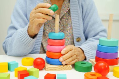 Asyalı yaşlı bir kadın, geliştirme oyunu oynuyor..