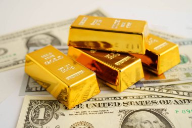 Gold bars on US dollar banknote money, finance trading investment business currency concept.