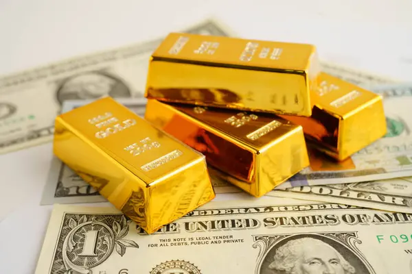 Gold bars on US dollar banknote money, finance trading investment business currency concept.
