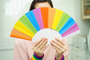 LGBT gökkuşağı bayrağı taşıyan Asyalı kadın.