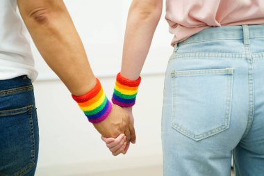 Gökkuşağı bilekliği takan Asyalı LGBT çifti..