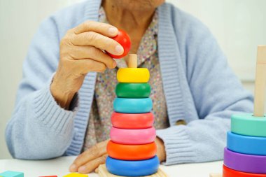 Asyalı yaşlı bir kadın, geliştirme oyunu oynuyor..