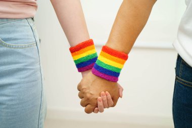 Gökkuşağı bilekliği takan Asyalı LGBT çifti..
