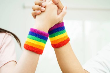 Gökkuşağı bilekliği takan Asyalı LGBT çifti..