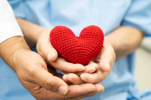 Hastanede kalbi kırmızı olan Asyalı yaşlı bir kadın..