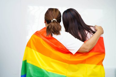 LGBT gökkuşağı bayrağı taşıyan Asyalı çift.