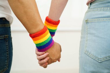 Gökkuşağı bilekliği takan Asyalı LGBT çifti..