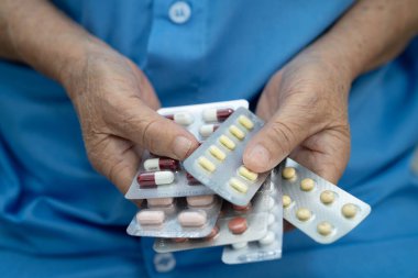 Asyalı yaşlı kadın elinde hap tutuyor, güçlü sağlıklı tıbbi konsept..