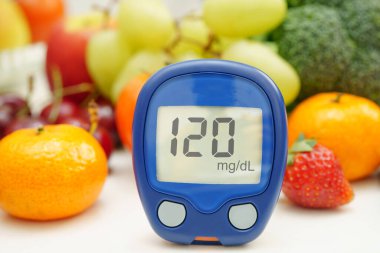 Kan şekeri seviyesini ölçmek için dijital glikoz ölçer. Diyabet için sebze ve meyve sağlıklıdır..