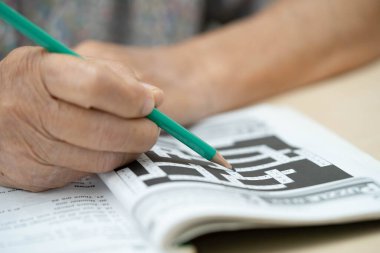 Yaşlı kadın sudoku bulmaca oyunu oynuyor.