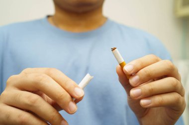 Sigarayı bırak, Asyalı adam kırıyor sigarayı elinde yok et.