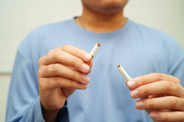 Sigarayı bırak, Asyalı adam kırıyor sigarayı elinde yok et.