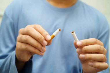 Sigarayı bırak, Asyalı adam kırıyor sigarayı elinde yok et.