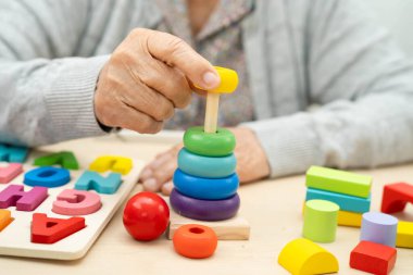 Asyalı yaşlı bir kadın, geliştirme oyunu oynuyor..