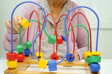 Asyalı yaşlı bir kadın, geliştirme oyunu oynuyor..