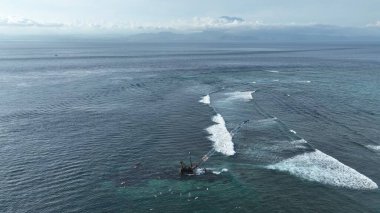 Endonezya sahilinde sörfçülerle birlikte terk edilmiş Crane.