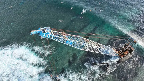Endonezya sahilinde sörfçülerle birlikte terk edilmiş Crane.