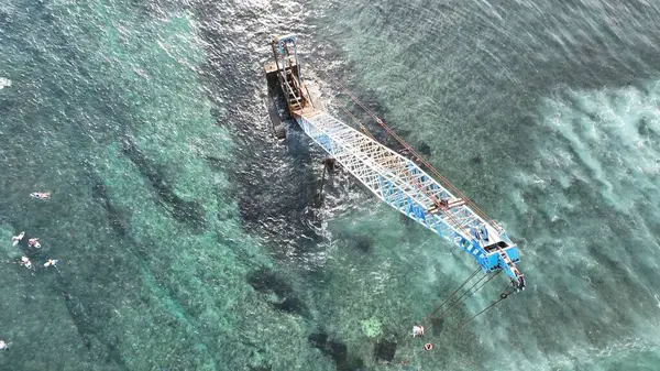 Endonezya sahilinde sörfçülerle birlikte terk edilmiş Crane.