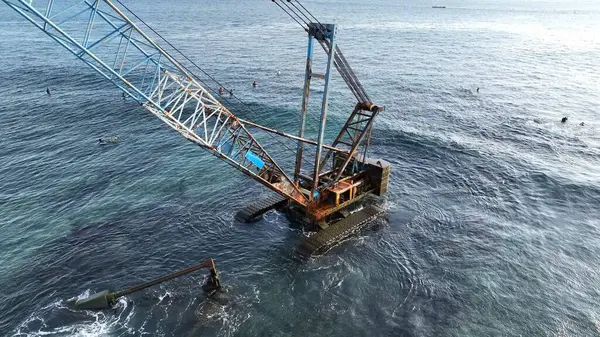 Endonezya sahilinde sörfçülerle birlikte terk edilmiş Crane.
