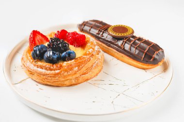 Böğürtlenli ve çikolatalı leziz ekler beyaz tabakta..