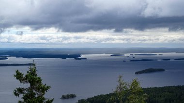 Ormanda bir dağ gölü manzarası. Yazın Koli Milli Parkı 'nın üzerinde koyu mavi bir gökyüzü..