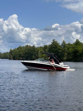 Gökyüzünün arka planında bir gölde motorlu tekne. Teknenin motoru çalışmıyorsa gölde ne yapacaksın?.
