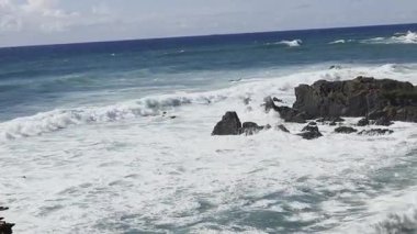 Atlantik Okyanusu 'nun güçlü gücü. Kayalık kıyı şeridinden koyu mavi suya ve büyük beyaz dalgalara kadar güneşli bir hava. Almograve, Portekiz 'deki Cabo Sardao' nun balıkçı patikasının bir parçası.