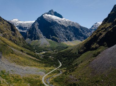 Karla ve yemyeşil vadilerle yükselen dağ zirveleri