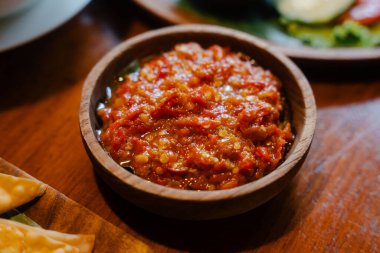 Ahşap masadaki ahşap kasede acı biber ezmesi.