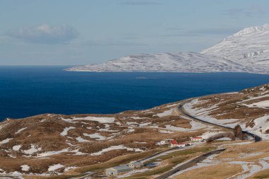 Mavi denizin üzerindeki görkemli karlı dağlar