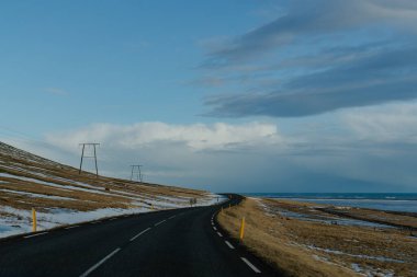 Dolambaçlı bir yolu ve mavi gökyüzü olan karlı dağ sıraları