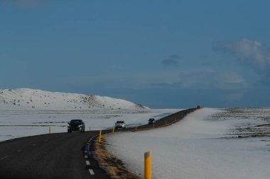 Dağlık arazide karlı yolda giden arabalar