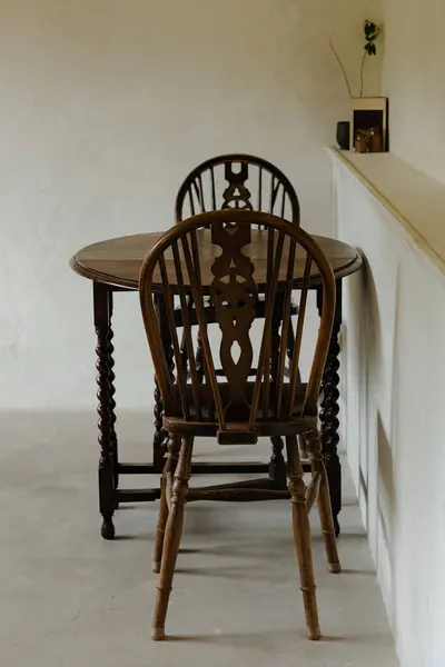 Minimalist bir odada eski ahşap sandalyeler ve masa