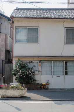 Güneşli bir günde bahçeli iki katlı bir ev.