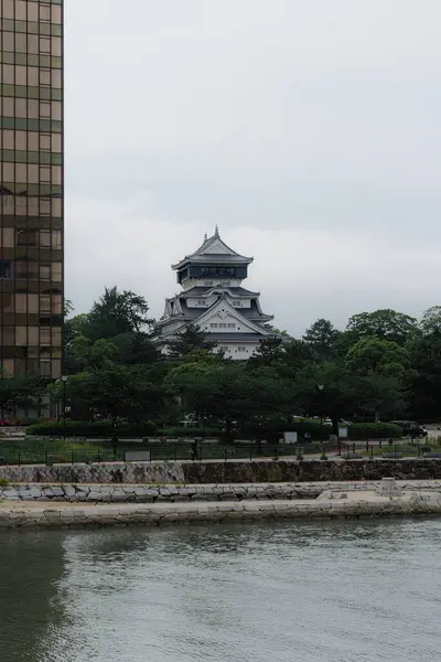 Arka planda ağaçlar ve modern binalarla Kokura Kalesi manzarası