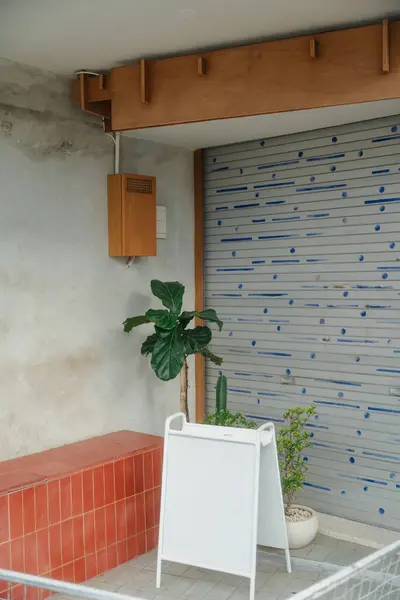 Açık kafe girişi, saksı bitkileri ve dekorları var.