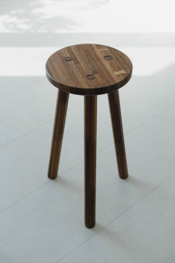 Simple wooden stool on light floor clipart