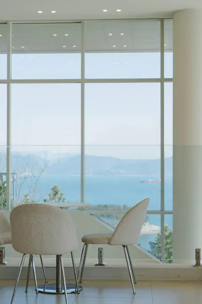 Modern sandalyeli okyanus manzaralı kafe.