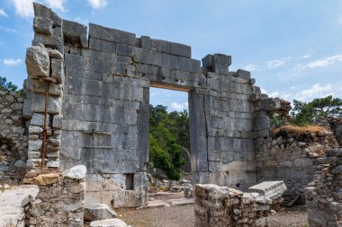 Olympos ancient ruin site view in popular resort town of Olympos, near Antalya, Turkey.  Olympos archaeological site with natural landscape.
