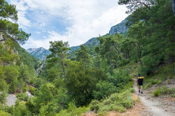 Hiker trekking in mountain in summer. Trekker with backpack on Lycian way hiking and trekking trail near Antalya, Turkey.