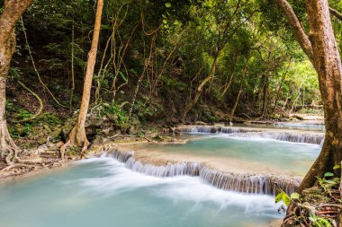 Ağaçlı, nehirli, şelaleli, güneşli ve rüya gibi atmosferli muhteşem orman manzarası. Tayland 'daki Erawan Şelalesi Ulusal Parkı' nda çekildi.