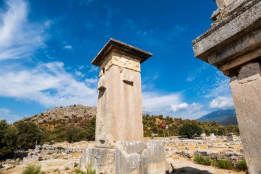 Xanthos Antik Şehir arkeoloji alanı. Türkiye 'nin Antalya, Kas kentindeki antik Xanthos kentinin günbatımında mezar anıtı ve kalıntıları. Lycia 'nın başkenti.