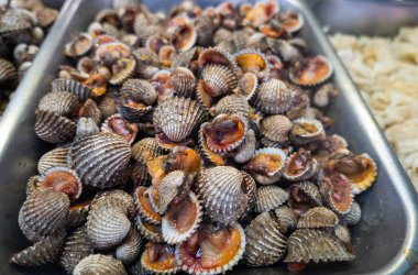 Kan midyesi, Tegillarca granosa bilimsel adıyla deniz ürünleri pazarında sergileniyor. Çiğ deniz midyelerinin yakın çekimi. Kızarmış midyeler için istiridye, Asya 'da popüler yemek, Çin.