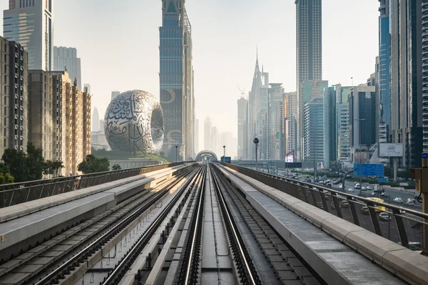 stock image Dubai, UAE - 11.3.2022: Dubai Metro rail with skyscrapers and Museum of the Future in Dubai in the frame. Dubai Cityscape skyline with modern urban transit system