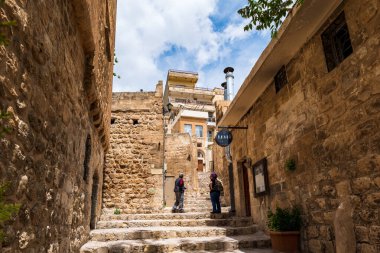 Mardin, Türkiye - 04.02.2022: Türkiye 'nin tarihi mimarisi ile Mardin eski kent sokak manzarası. Mardin, UNESCO Dünya Mirasları listesinde yer alıyor