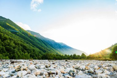 Kopyalama uzayı için gökyüzü güçlü güneş ışığıyla kaplı açık havada yürüyüş yapmak. Georgia 'nın Svaneti bölgesinde Mestia köyü yakınlarındaki macera yürüyüşü rotasında dağlar ve nehirler..